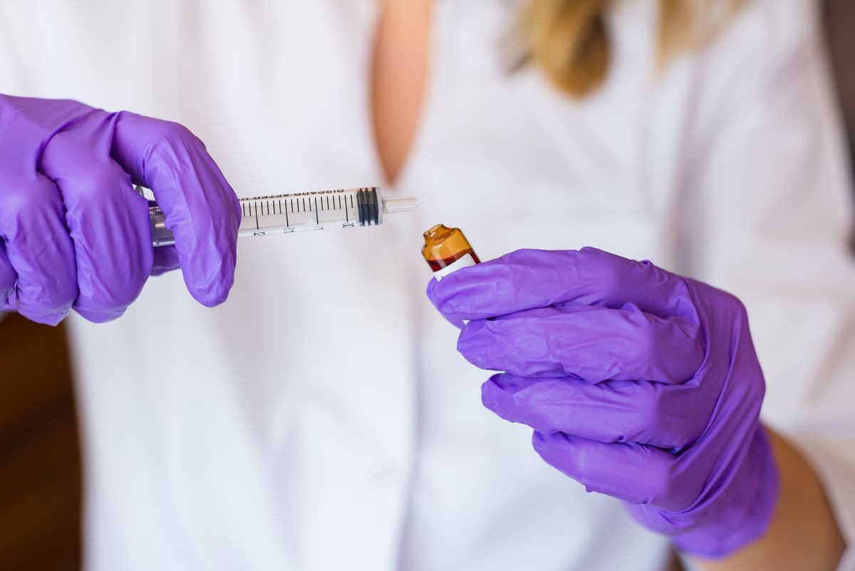 Woman hands holding syringe ampoule filled with b12 vitamine
